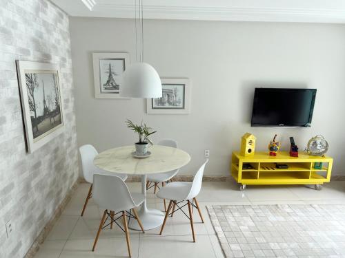 a dining room with a table and chairs and a tv at AP VIAJANTE in Domingos Martins