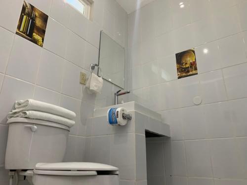 a white bathroom with a toilet and a mirror at Posada Del Valle in Valle de Guadalupe