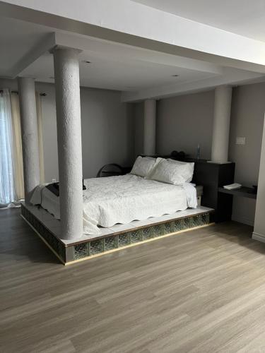 Un dormitorio con una cama con una columna. en Motel du rosier, en Baie-Comeau