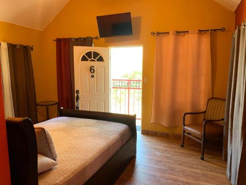 um quarto com uma cama e uma porta com uma janela em Posada Del Valle em Valle de Guadalupe