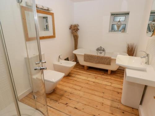 a bathroom with a tub and a toilet and a sink at Rock House in Narberth