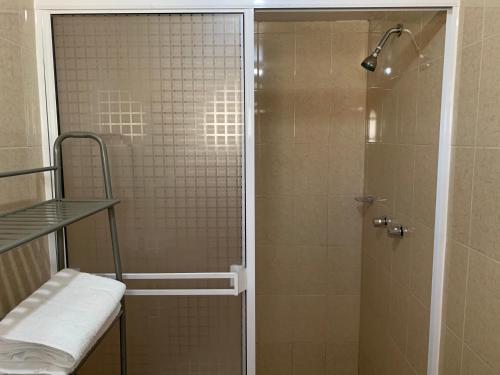 a shower with a glass door in a bathroom at Posada Del Valle in Valle de Guadalupe