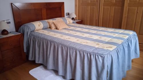a bedroom with a large bed with a blue blanket at Casa Rural Buenavista in Mogarraz