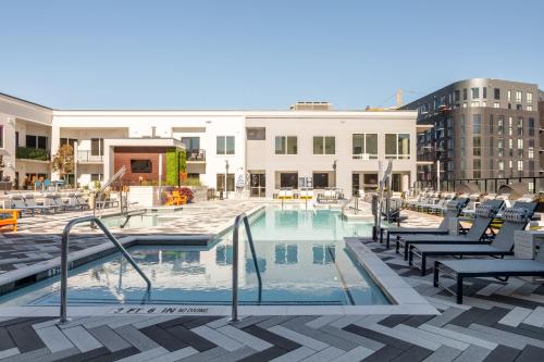 a swimming pool with chairs and a building at Mint House Nashville - The Gulch - Division St in Nashville