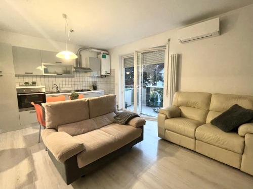 uma sala de estar com um sofá e uma cozinha em Diamond House em Mattarello