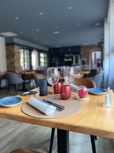 a wooden table with wine glasses on it at La Rose in Juliénas