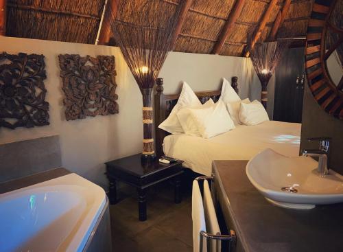 uma casa de banho com uma cama, um lavatório e uma banheira em Little Eden Guest Lodge em Vanderbijlpark