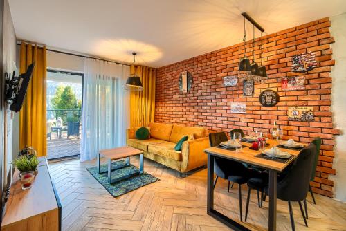 a living room with a table and a brick wall at Loft Apart View & Wellness in Szczyrk
