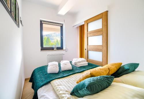 um quarto com 2 camas com almofadas e uma janela em Loft Apart View & Wellness em Szczyrk