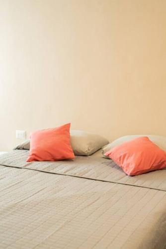 two orange pillows sitting on a bed in a room at Amplia casa con 3 habitaciones para hospedaje in Chetumal
