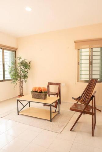 a living room with a table and a chair and a coffee table at Amplia casa con 3 habitaciones para hospedaje in Chetumal