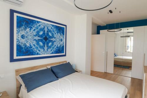 ein Schlafzimmer mit einem Bett mit einem blauen Gemälde an der Wand in der Unterkunft Appartamento incantevole fronte mare in Villa Rosa