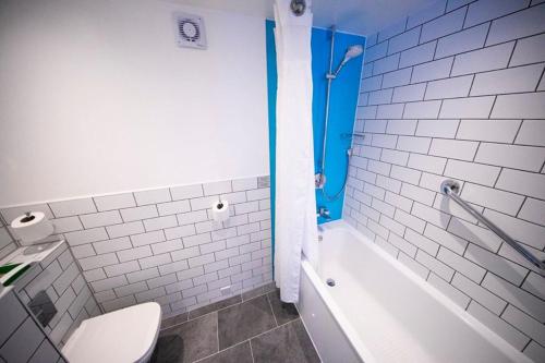 uma casa de banho com uma banheira branca e um WC. em Holiday Inn Kenilworth - Warwick, an IHG Hotel em Kenilworth