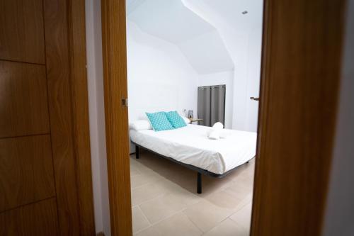 Un dormitorio con una cama con almohadas azules. en Apartamento Avilés, en Ronda