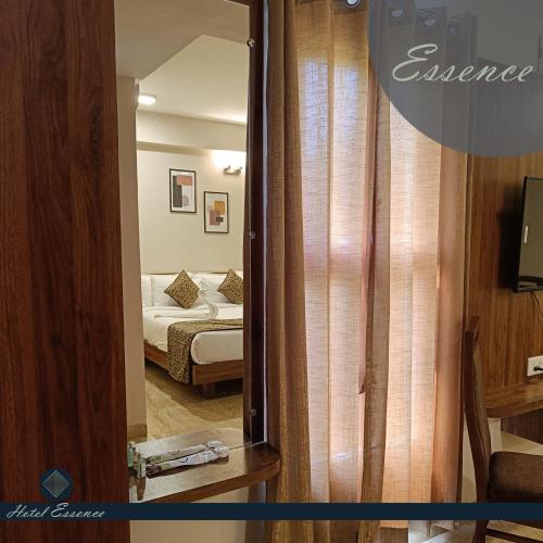 a mirror in a room with a bed and a bedroom at Hotel ESSENCE in Vellore