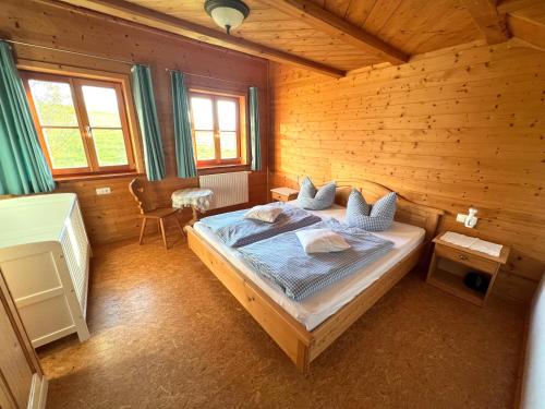 a bedroom with a bed in a wooden cabin at Ferienhaus Serafina in Rieden am Forggensee