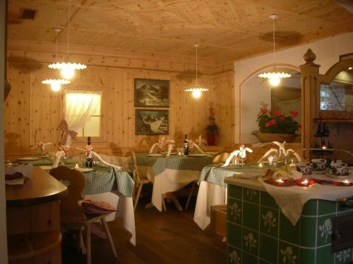 a restaurant with green and white tables and chairs at Alpotel Dolomiten in Molveno