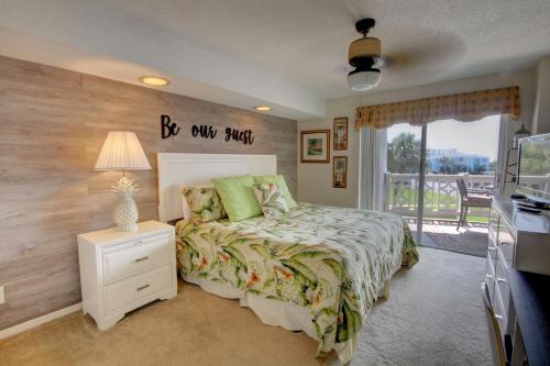 a bedroom with a bed with a sign on the wall at El Matador 235 - Beautiful views of the courtyard and Gulf of Mexico in Fort Walton Beach