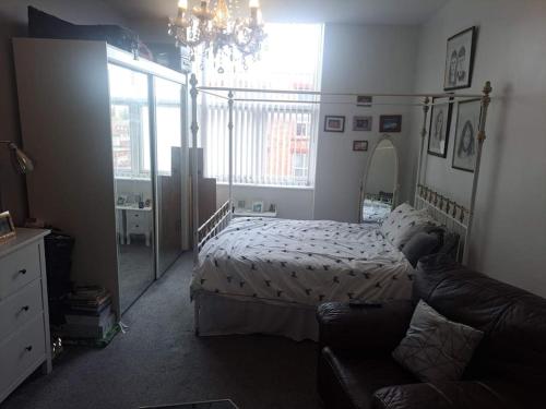 a bedroom with a bed and a couch at Flat near City Centre Liverpool 10 mins to Arena in Liverpool