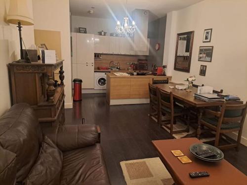 a living room with a couch and a table and a kitchen at Flat near City Centre Liverpool 10 mins to Arena in Liverpool