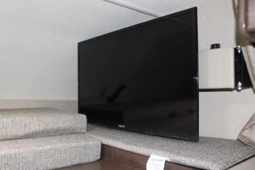 duży telewizor z płaskim ekranem siedzący na ścianie w obiekcie AJ-XL RV Rental w mieście Reseda