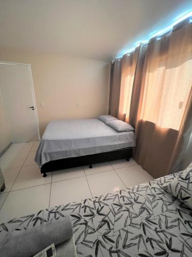 a small bedroom with two beds and a window at Sol de Bora Bora 101 in Salvador
