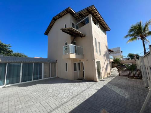 uma grande casa branca com uma palmeira em Sol de Bora Bora 101 em Salvador