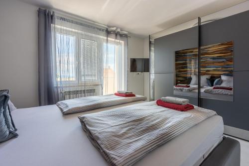 a bedroom with two beds and a large window at House Moderna 2 in Crikvenica