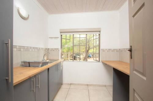 マールロス・パークにあるEye of Kruger - Spacious holiday home with splash pool and bomaのシンクと窓のあるキッチン