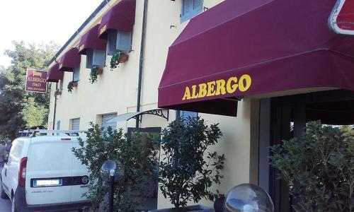 HOTEL Via Emilia Ovest 224 SELF CHECK-IN في بارما: مظلة أرجوانية مع علامة ألبيرجو على مبنى