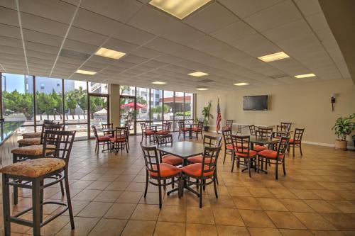 a dining room with tables and chairs and windows at El Matador 420 - Beautiful views of the Gulf and pool in Fort Walton Beach