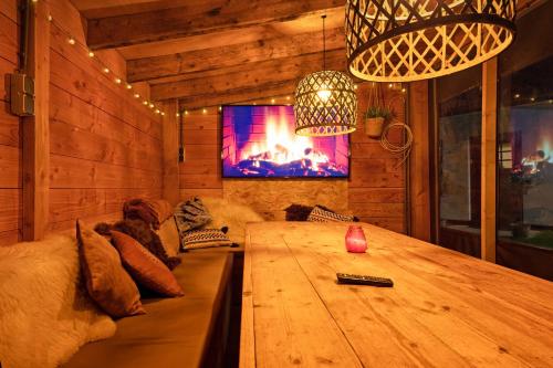 a living room with a wooden table and a tv at The island life Texel - Wellness in De Koog