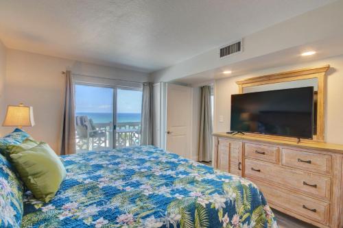 1 dormitorio con 1 cama con TV y vestidor en El Matador 457 - Gulf front with beautiful views of the Gulf and pool, en Fort Walton Beach