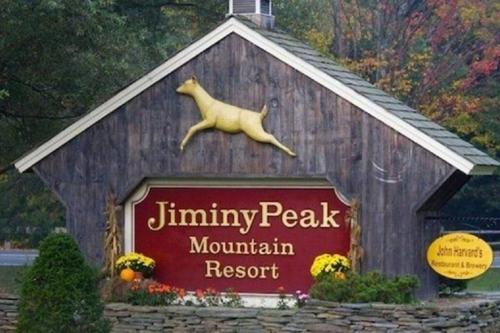 a sign for a mountain resort with a dog on top at Ski On Off 1BR Suite 1st Flr Sleeps 4 Jiminy Peak in Hancock