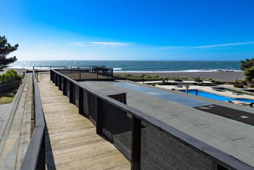 a boardwalk leading to the beach and a swimming pool at Hotel Punta Sirena in Curanipe