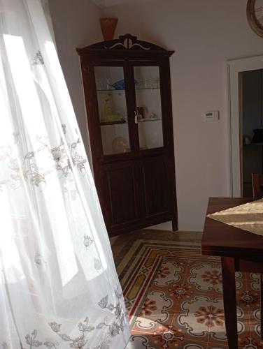 a white curtain in a room with a cabinet at Lisa Dimora Salentina in Andrano