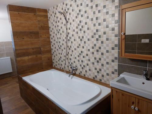 ein Badezimmer mit einer Badewanne und einem Waschbecken in der Unterkunft Chalupa a apartmány Marika in Černý Důl