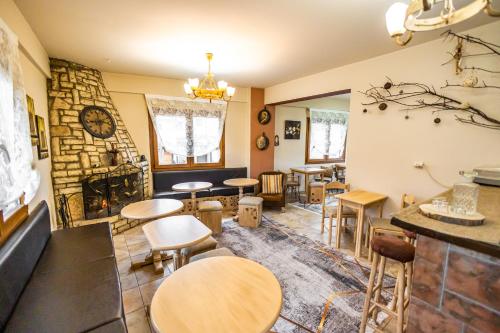 カラブリタにあるEnastronのテーブルと椅子、暖炉のあるレストラン
