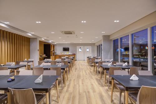 ein Esszimmer mit blauen Tischen und Stühlen in der Unterkunft Transamerica Fit Rio Verde in Rio Verde