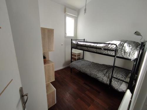 une petite chambre avec deux lits superposés et une fenêtre dans l'établissement Appartement Saint Palais sur Mer à 100 mètres de la plage, à Saint-Palais-sur-Mer