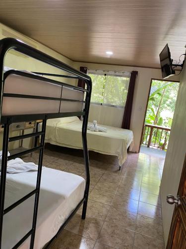 a bedroom with two bunk beds and a balcony at Cabañas Río Escondido en La Fortuna in Fortuna