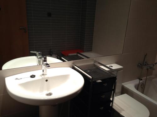La salle de bains est pourvue d'un lavabo et d'un miroir. dans l'établissement Apartamentos Benicassim, à Benicàssim