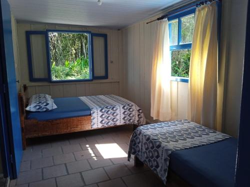 a bedroom with two beds and a window at Pousada Oceano Azul in Ilha do Mel