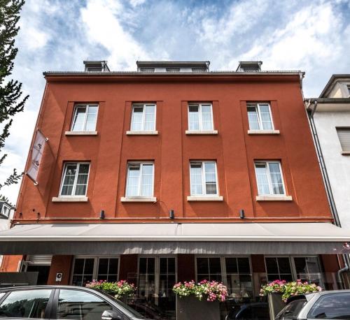 un edificio rojo con ventanas blancas en una calle en Beau-Séjour, en Mondorf-les-Bains