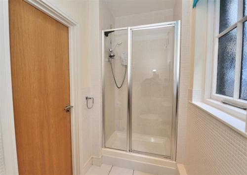 y baño con ducha y puerta de cristal. en Coram Lodge, en Lyme Regis