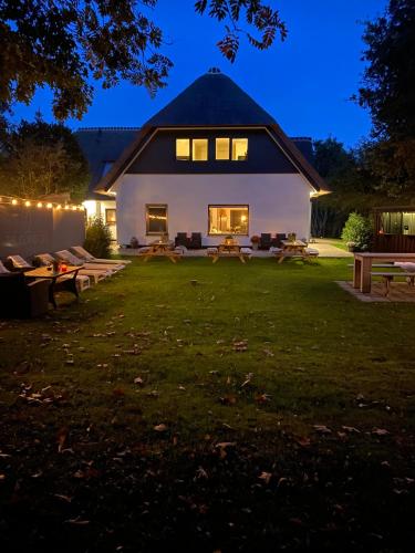a large white house with a yard at night at The island life Texel - Wellness in De Koog