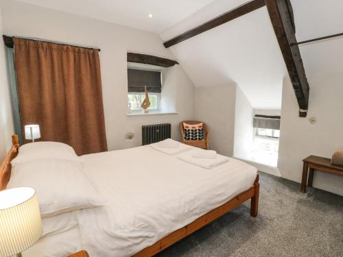 a bedroom with a large white bed and a window at Stabla in Pwllheli