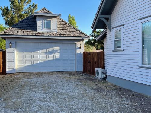 a garage with a white garage door next to a house at Holland House - Historic and Sophisticated in Alpine