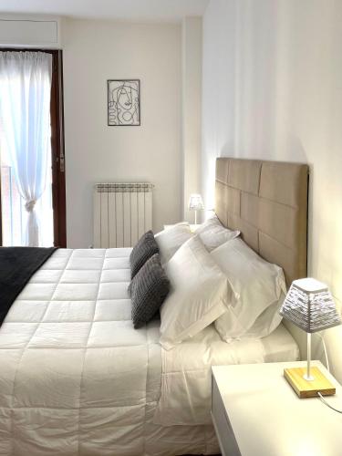 Filo Guest House في بيروجيا: غرفة نوم بسرير كبير عليها شراشف ووسائد بيضاء