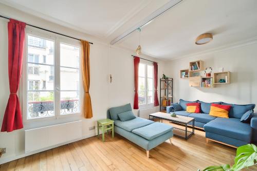 een woonkamer met een blauwe bank en 2 stoelen bij Comfortable apartment in the heart of Paris - Welkeys in Parijs